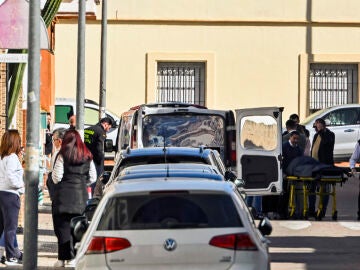 Empleados de la funeraria trasladan el cuerpo sin vida de la mujer 