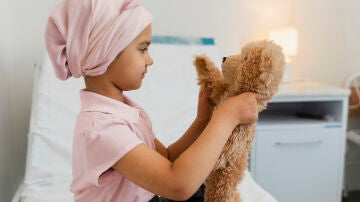 Una niña en el hospital juega con su peluche