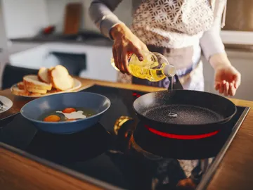 Una mujer cocinando con aceite Una mujer cocinando con aceite