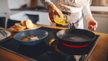 Una mujer cocinando con aceite