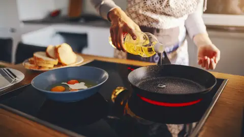 Una mujer cocinando con aceite Una mujer cocinando con aceite