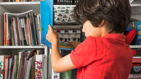 Un niño coloca un libro Un niño coloca un libro