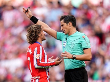 Munuera Montero y Antoine Griezmann en el Metropolitano