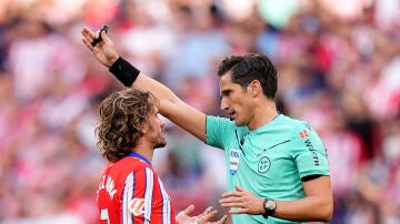 Munuera Montero y Antoine Griezmann en el Metropolitano