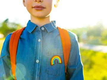 Un niño con una camisa vaquera con un arcoíris Un niño con una camisa vaquera con un arcoíris