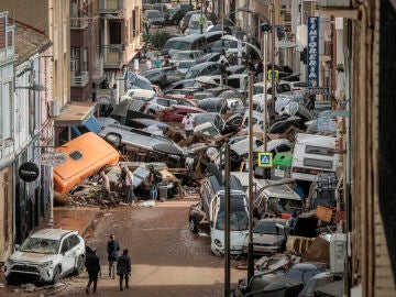 Vehículos amontonados en una calle tras las intensas lluvias de la fuerte DANA en Alfafar