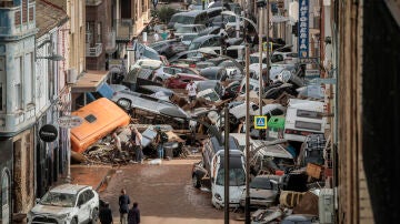 Vehículos amontonados en una calle tras las intensas lluvias de la fuerte DANA en Alfafar