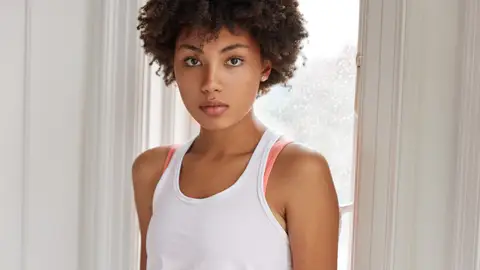 Mujer con camiseta de tirantes y tira del sujetador Mujer con camiseta de tirantes y tira del sujetador