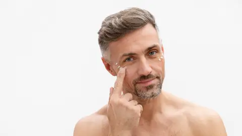 Hombre aplicándose cosméticos Hombre aplicándose cosméticos