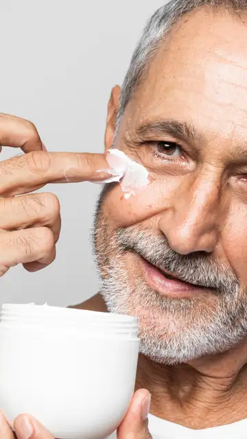 Hombre aplicándose cosméticos Hombre aplicándose cosméticos