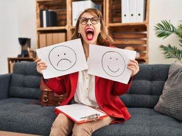 Una mujer con carteles de felicidad y tristeza
