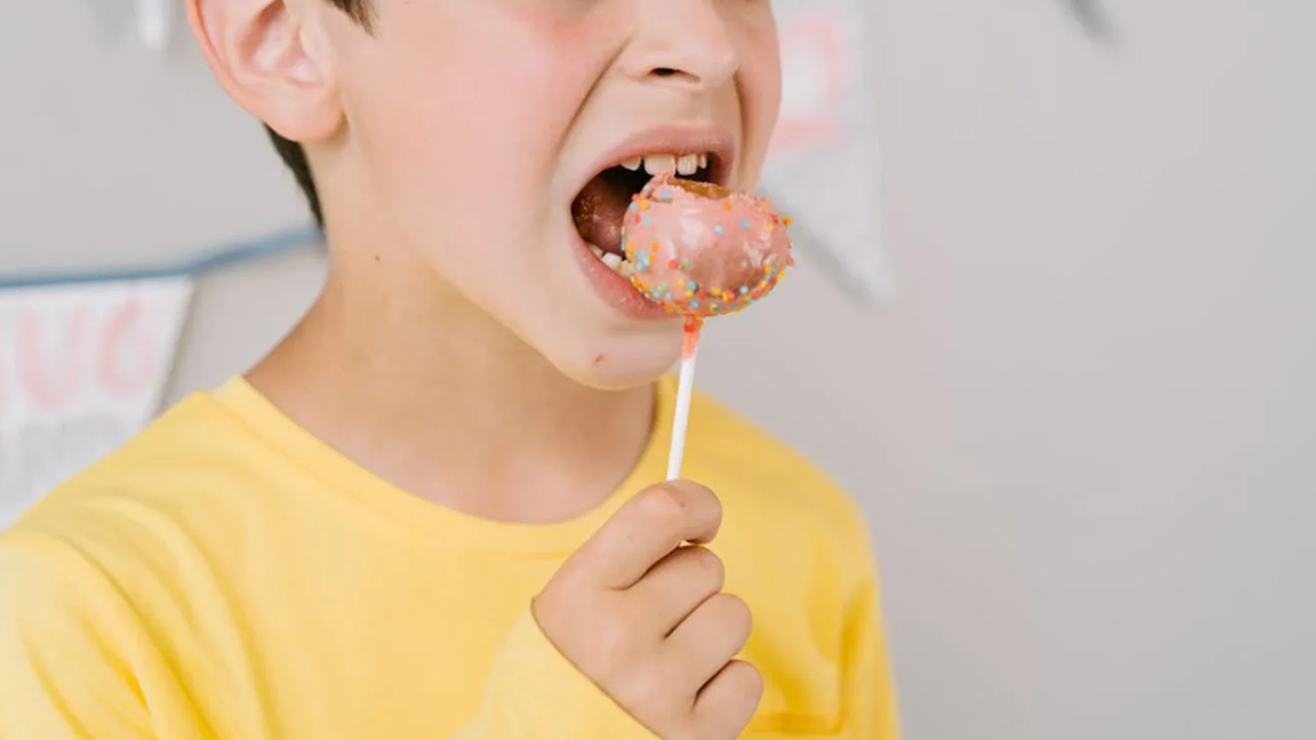 Imagen de archivo de un niño comiendo un cake pops. Imagen de archivo de un niño comiendo un cake pops.