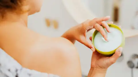 Mujer con un producto cosmético Mujer con un producto cosmético