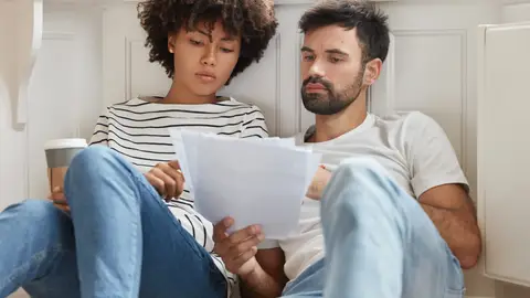 Una pareja leyendo juntos sus anotaciones Una pareja leyendo juntos sus anotaciones