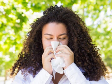 Mujer con alergia son&aacute;ndose