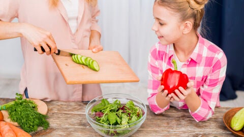 Una madre y su hija preparan una ensalada