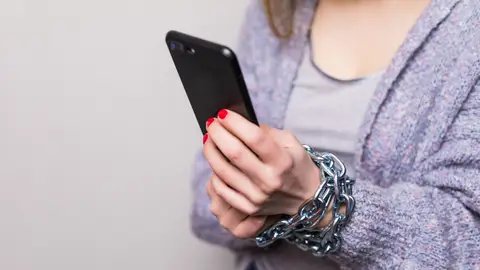 Persona atada a su teléfono móvil Persona atada a su teléfono móvil