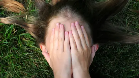 Mujer tapándose la cara con las manos Mujer tapándose la cara con las manos