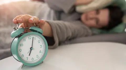 Una mujer apaga el despertador Una mujer apaga el despertador