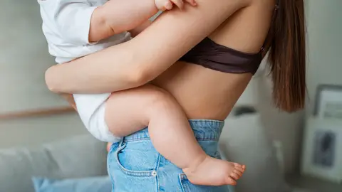 Una madre con su bebé en brazos Una madre con su bebé en brazos