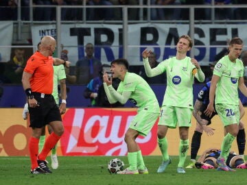 Los jugadores del Barcelona protestan una decisión de Szymon Marciniak