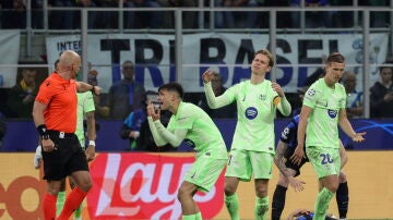 Los jugadores del Barcelona protestan una decisión de Szymon Marciniak