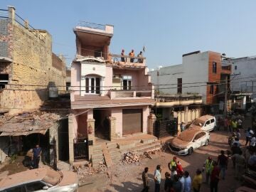 Residentes indios inspeccionan una casa dañada tras un bombardeo transfronterizo desde Pakistán