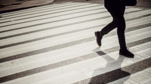Imagen de archivo de un hombre cruzando por un paso de cebra.