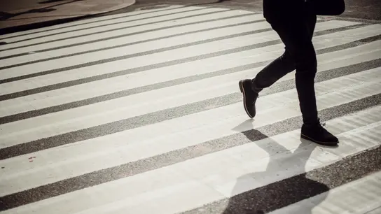Imagen de archivo de un hombre cruzando por un paso de cebra. Imagen de archivo de un hombre cruzando por un paso de cebra.