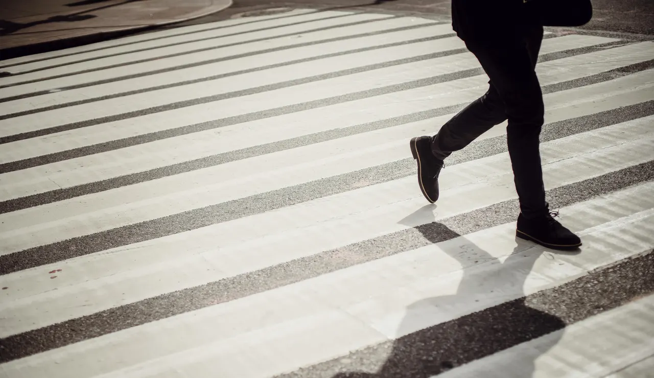 Imagen de archivo de un hombre cruzando por un paso de cebra.
