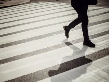 Imagen de archivo de un hombre cruzando por un paso de cebra. Imagen de archivo de un hombre cruzando por un paso de cebra.