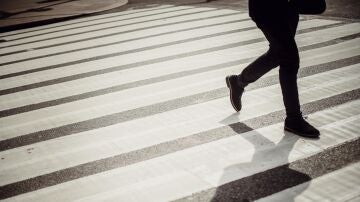 Imagen de archivo de un hombre cruzando por un paso de cebra.