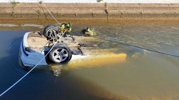 Bomberos rescatando el coche hundido en un canal de Cartaya (Huelva)