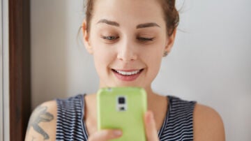 Una mujer consulta el teléfono móvil