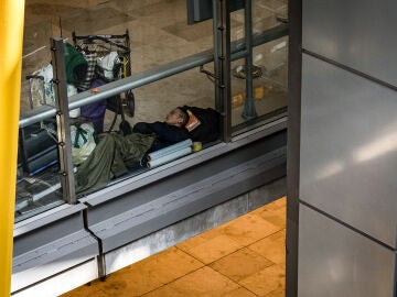 Un hombre duerme en la T4 del Aeropuerto Adolfo Suárez-Madrid Barajas