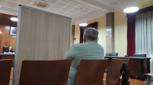 El acusado, sentado en el banquillo y separado por un biombo, escucha la declaraci&oacute;n de su exmujer