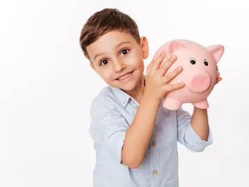 Un niño sujetando una hucha Un niño sujetando una hucha