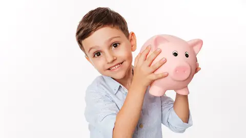 Un niño sujetando una hucha Un niño sujetando una hucha