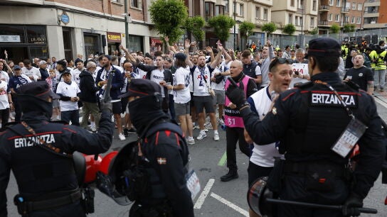 Agentes de la Ertzaintza vigilan a un grupo de aficionados del Tottenham