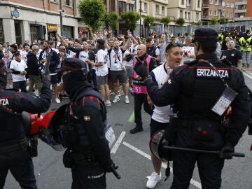 Agentes de la Ertzaintza vigilan a un grupo de aficionados del Tottenham