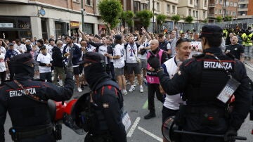 Agentes de la Ertzaintza vigilan a un grupo de aficionados del Tottenham