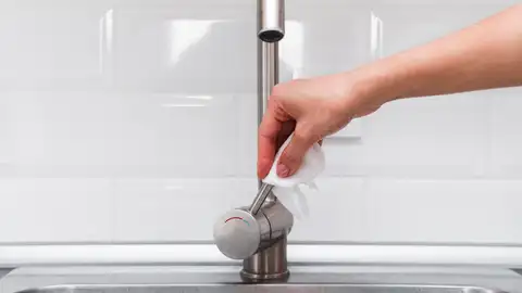 Persona limpiando un grifo Persona limpiando un grifo