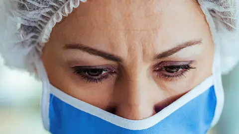 Mujer con mascarilla y mirada angustiada Mujer con mascarilla y mirada angustiada