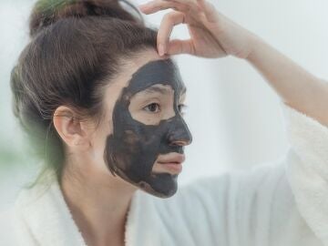 Imagen de archivo de una chica poniéndose una mascarilla