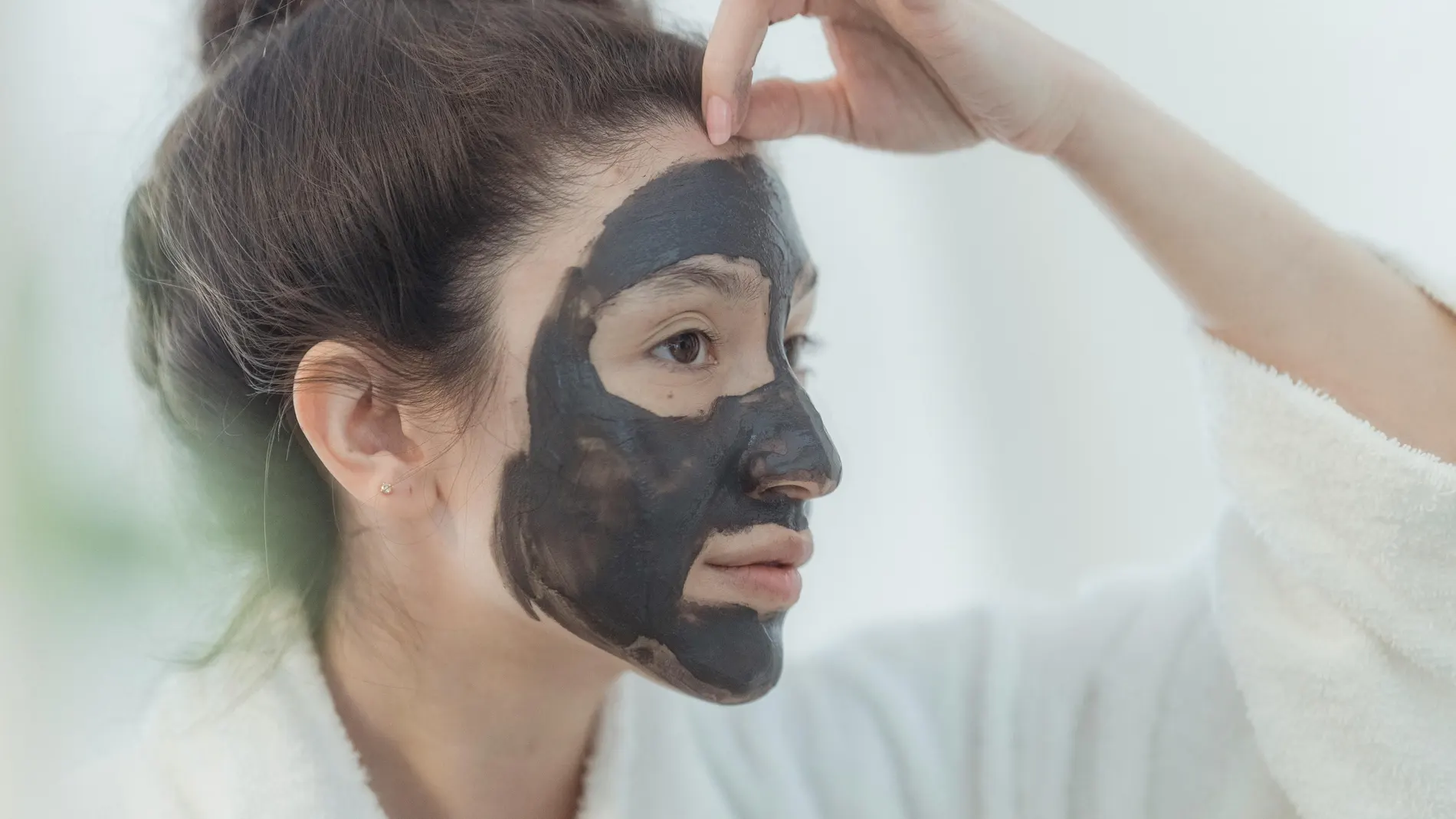 Imagen de archivo de una chica poniéndose una mascarilla Imagen de archivo de una chica poniéndose una mascarilla