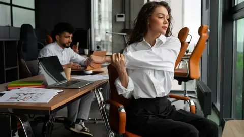 Una mujer realiza estiramientos en la oficina Una mujer realiza estiramientos en la oficina