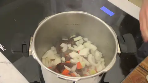 Introduce las hortalizas picadas y la cabeza de ajo entera en la olla Introduce las hortalizas picadas y la cabeza de ajo entera en la olla