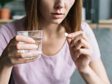 Mujer tomando un medicamento Mujer tomando un medicamento