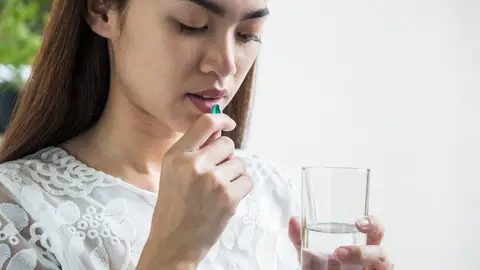 Mujer tomando un medicamento Mujer tomando un medicamento