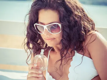Mujer oliendo un perfume Mujer oliendo un perfume